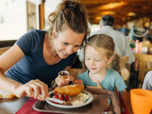 Breakfast for young and old at the Wiriehorn Mountain Hotel Mother spreads Nutella on a croissant for her daughter