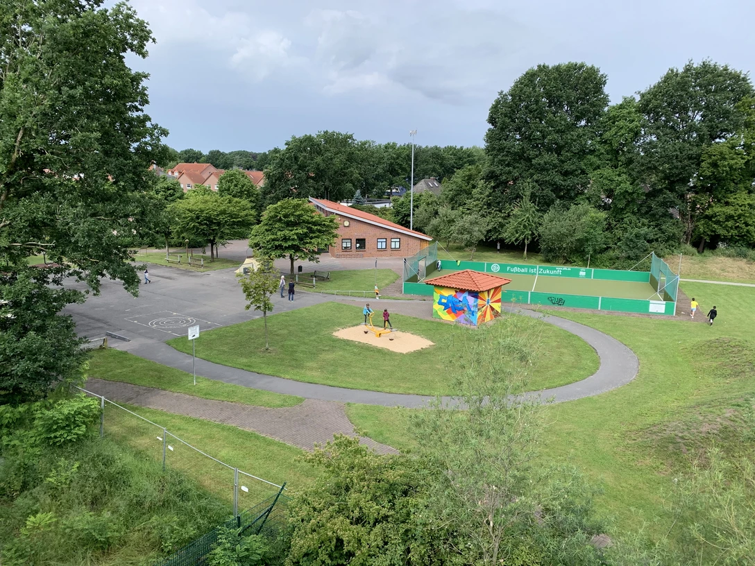 Casa Vogelperspektive.JPG Eine grüne Parklandschaft aus der Vogelperspektive zeigt einen Spielplatz mit farbig bemaltem Häuschen. Umliegend sind Wege, Bäume und eine Sportfläche zu sehen.