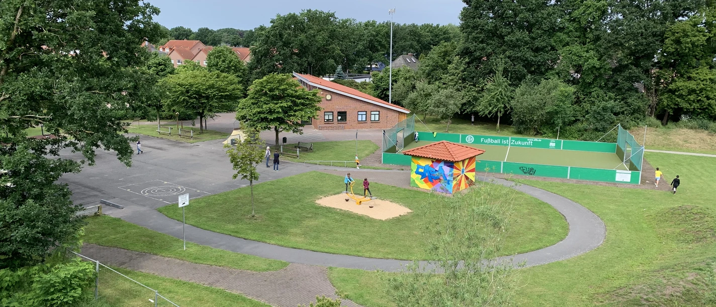 Casa Vogelperspektive.JPG Eine grüne Parklandschaft aus der Vogelperspektive zeigt einen Spielplatz mit farbig bemaltem Häuschen. Umliegend sind Wege, Bäume und eine Sportfläche zu sehen.