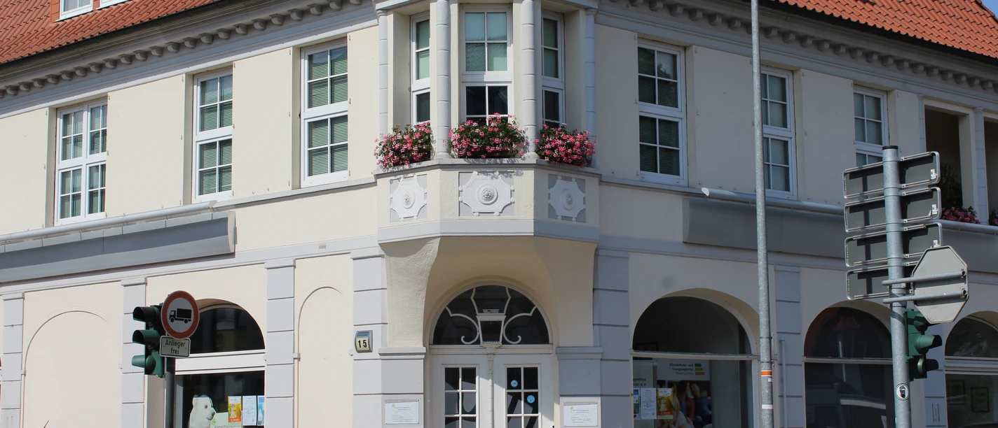 Stadtvilla Eine zweigeschossige weiße Stadtvilla mit rotem Ziegeldach und dekorativem Erker zur Straßenecke.
