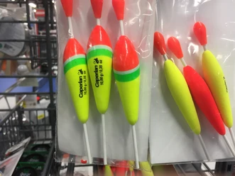 angeln3.JPG Verschiedene leuchtend bunte Angelschwimmer, in Regalen aufgehängt, perfektes Zubehör für Angler.