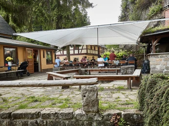 Biergarten unter Felswänden Neumannmühle Berghütte und Wirtshaus