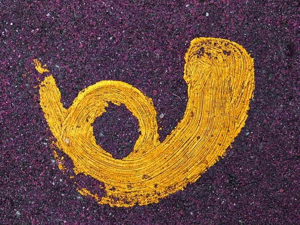 Hörnchen Gelbe, spiralförmige Linie auf violettem Asphalt mit kleinen violetten Partikeln verstreut.