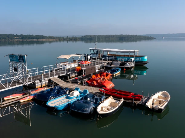 View of the Vineta dock on Lake Störmthal in the Leipzig New Lake District, where various pedal boats, motorboats, and kayaks are available for rent