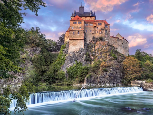 Kriebstein Castle on a rocky hill with a waterfall