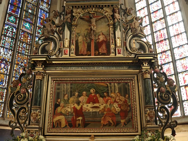 Altar der Johanniskirche Herford mit reich verzierten Kunstwerken und bunten Glasfenstern im Hintergrund.