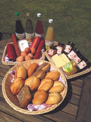 Lödings Bauernhof am See_Frühstück.jpg Blick auf verschiedene Waren wie Käse, Wurst, Eier und andere Lebensmittel