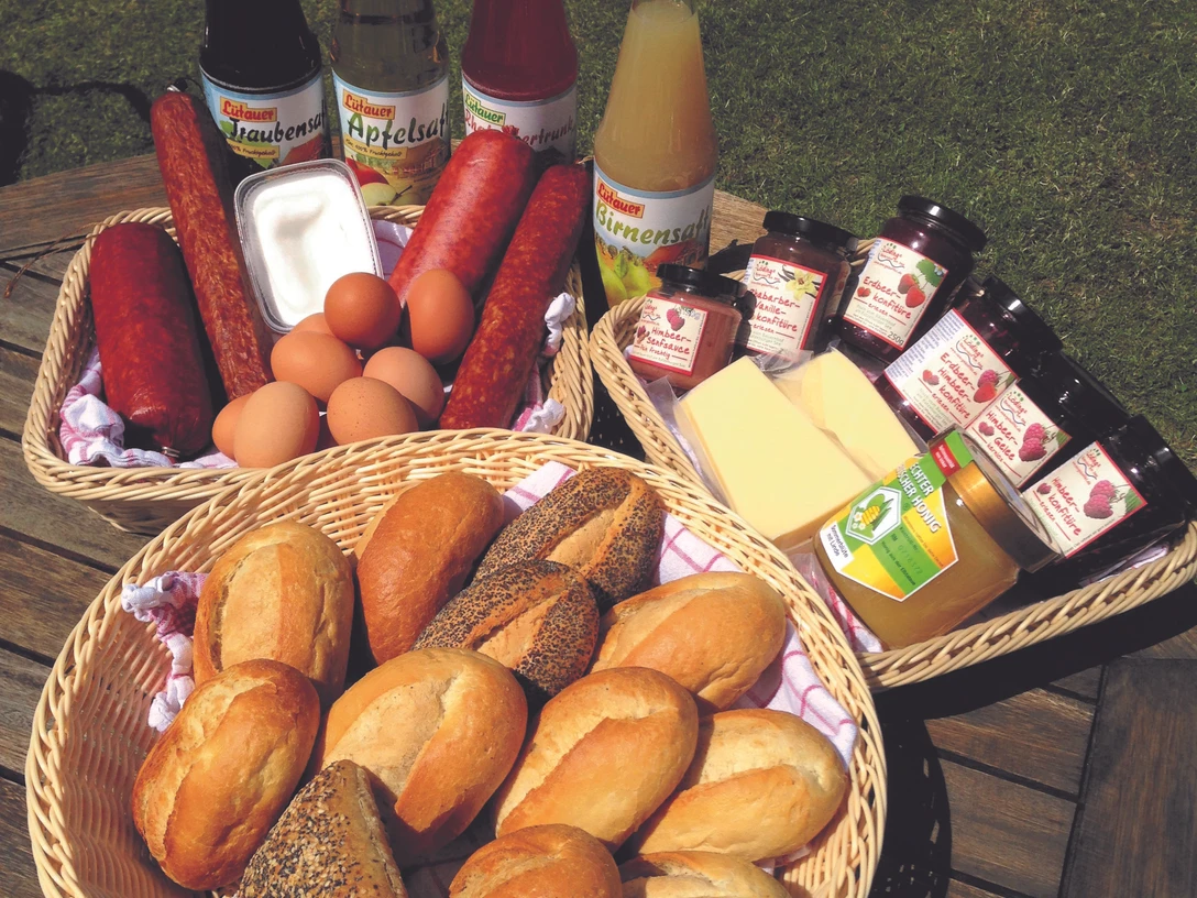 Lödings Bauernhof am See_Frühstück.jpg Blick auf verschiedene Waren wie Käse, Wurst, Eier und andere Lebensmittel