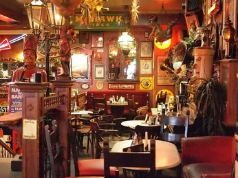 brösel2.jpg Ein gemütliches, rustikales Pub mit Holztischen und Wänden voller vielfältiger Dekorationen.