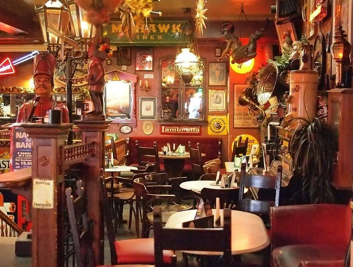 brösel2.jpg Ein gemütliches, rustikales Pub mit Holztischen und Wänden voller vielfältiger Dekorationen.