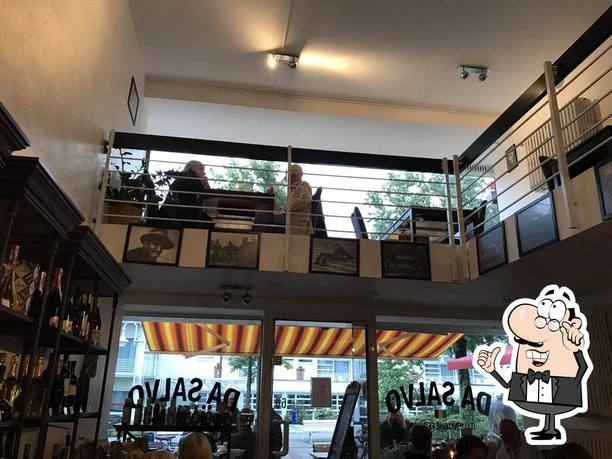 Da-Salvo-design.jpg Restaurant mit Galerie, zeigt Gäste beim Essen auf einer erhöhten Plattform, umgeben von Regalen.