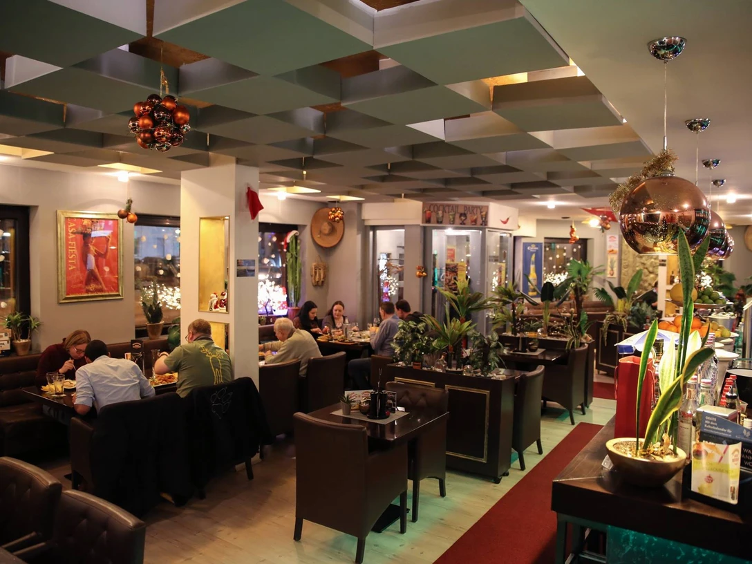 15874658_598438367015844_7804153406967349204_o.jpg Das Bild zeigt die Innenansicht des Restaurants an einem lebendigen und gut besuchten Nachmittag. Die Einrichtung ist klassisch und erzeugt ein familiäres Ambiente.