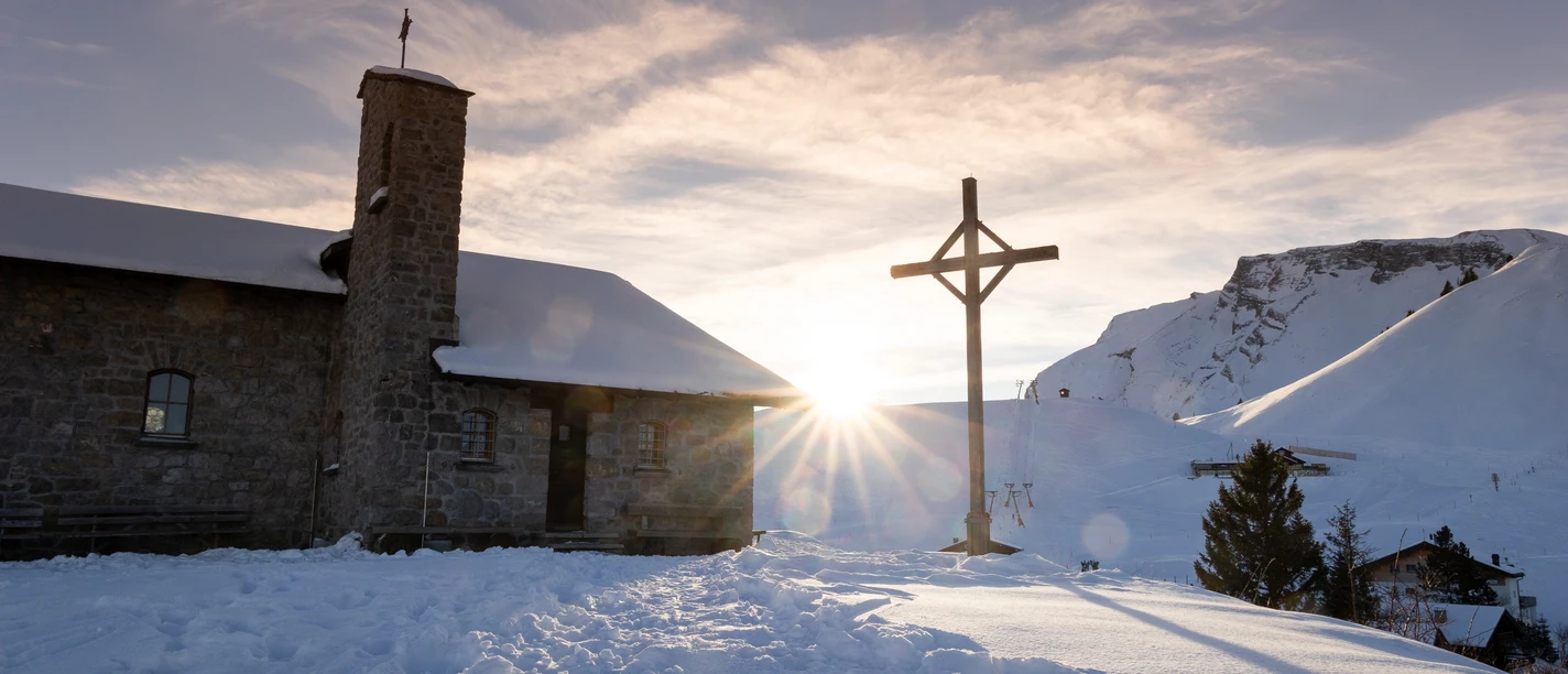 klewenkapelle-kreuz-winter-schnee-klewenalp.jpg Klewenalp-Kapelle im Schnee mit Sonne im Hintergrund.