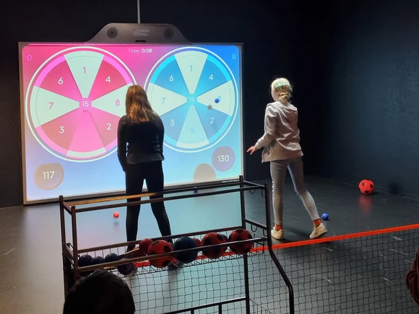 Two children play darts on the XXL game wall from Team-Duell Leipzig