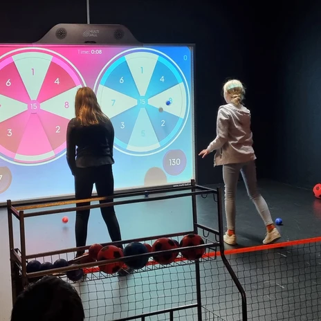 Fléchettes - Multiplex Lounge Team-Duell Leipzig Deux enfants jouent aux fléchettes sur le mur de jeux XXL de Team-Duell Leipzig