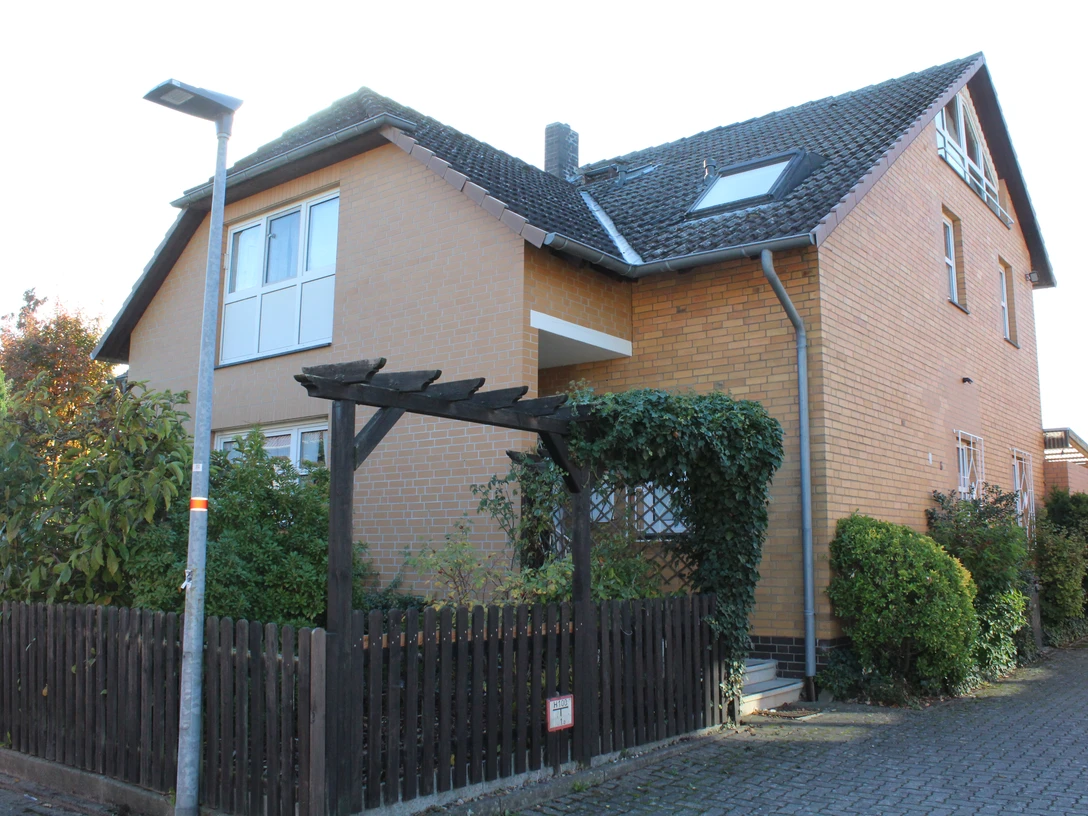 Schlagowsky Ein zweistöckiges Backsteinhaus mit Satteldach, umgeben von Hecken und einem Holzzaun im Vordergrund.A two-storey brick house with a pitched roof, surrounded by hedges and a wooden fence in the foreground.Et murstenshus i to etager med skråt tag, omgivet af hække og et træhegn i forgrunden.Een bakstenen huis van twee verdiepingen met een schuin dak, omringd door heggen en een houten hek op de voorgrond.