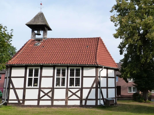 mardorf-kirche.JPG Historische Fachwerkkirche mit Glockenturm und rotem Ziegeldach, umgeben von grünem Rasen und Bäumen.