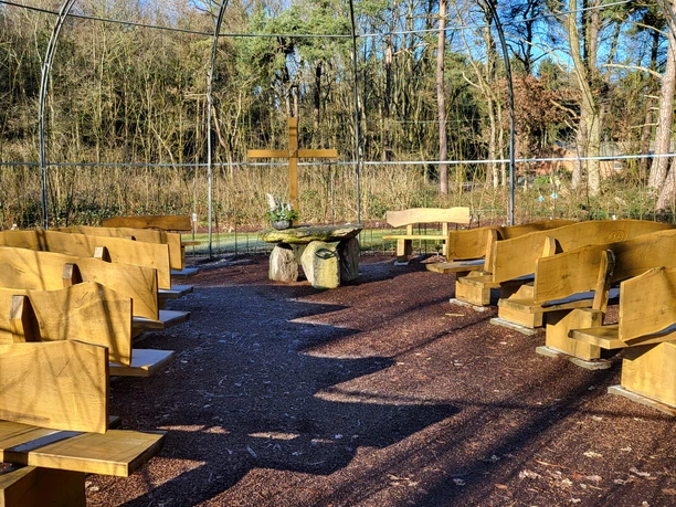 Weidenkirche in Lahn (5) © Naturpark Hümmling e. V..jpg Offene Weidenkirche mit Holzbänken, Altar aus Steinen und Kreuz inmitten eines lichten Waldes