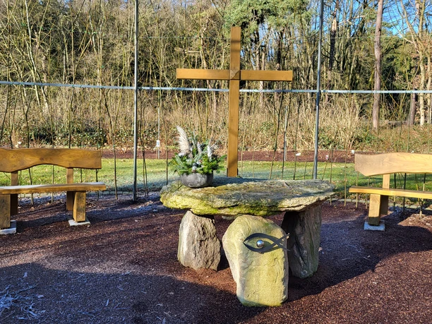 Weidenkirche in Lahn (7) © Naturpark Hümmling e. V..jpg Steinaltar mit Blumenschmuck und Holzkreuz zwischen zwei Bänken in der Weidenkirche Lahn.