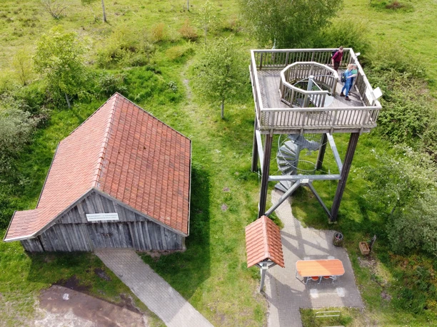 Kapellenmoorgraben_Niederlangen_ Aussichtsturm Informationshütte ©Naturpark Hümmling e. V. (8).jpg Holzturm mit Aussichtsplattform neben einer kleinen Informationshütte in grüner Moorlandschaft
