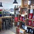 Wild - Der Kaffeeladen in Osnabrück Eine helle Kaffeeverkaufsstelle mit Regalen voller Kaffeetüten und einer ansprechenden Einrichtung.