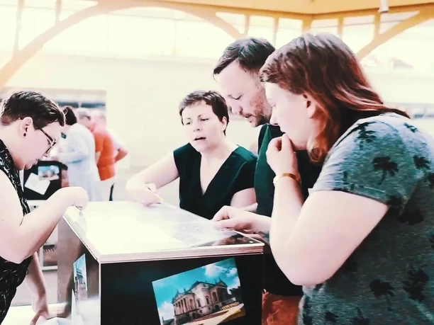 Mobile Escape Game - Freizeitaktivitäten in Leipzig Eine Gruppe von Menschen ist um eine mobile Rätselkiste versammelt.