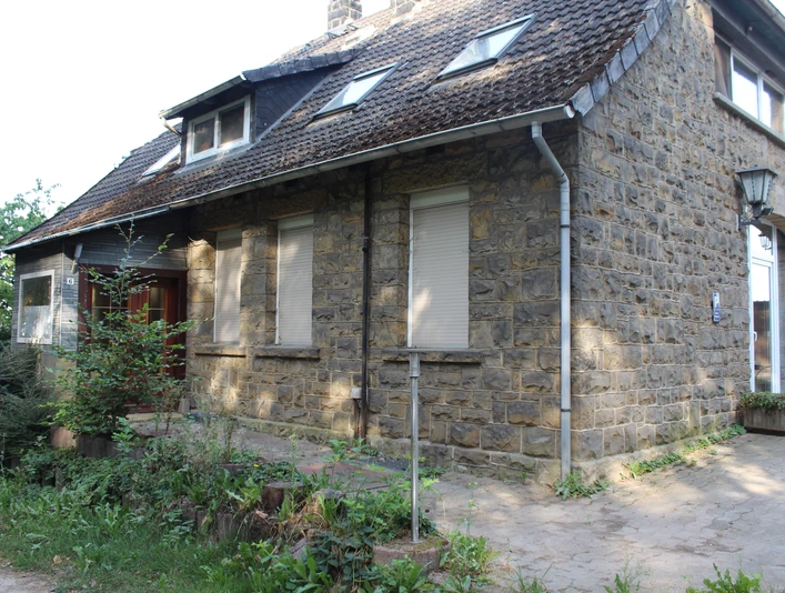 Ferienwohnung Reuter Münchehagen Rustikales Steinhaus mit weißen Fenstern und Schindeldach in grüner Umgebung in Münchehagen.