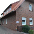 Backsteinbau mit Satteldach im ländlichen Uchte, umgeben von Bäumen und gepflastertem Außenbereich.Brick building with gabled roof in rural Uchte, surrounded by trees and a paved outdoor area.Murstensbygning med sadeltag i landlige Uchte, omgivet af træer og et asfalteret udendørs område.Bakstenen gebouw met zadeldak in het landelijke Uchte, omgeven door bomen en een geplaveide buitenruimte.