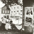 Markt mit Litfaßsäule (Bildnachweis: Stadtarchiv Lübbecke) Ein Marktplatz mit Litfaßsäule, Verkaufsständen und historischen Gebäuden im Hintergrund.