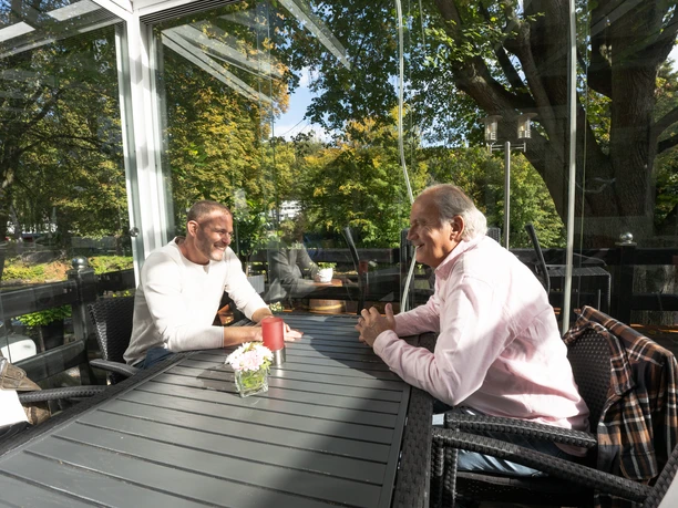 Café Hubraum Zwei Personen an einem Tisch im Wintergarten