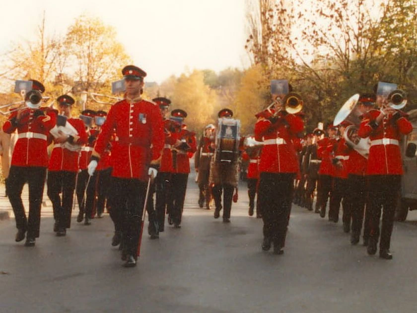 Abschiedsparade der 2nd armoured division Eine Militärkapelle marschiert in roten Uniformen mit Trompeten und Trommeln auf einer Straße im Herbst.