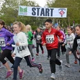 City Lauf - Stadt Espelkamp Kinder in Sportkleidung starten vor einem Banner bei einem Stadtlauf mit jubelnder Menge.