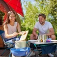 Camping im Wakenitz Camp in Rothenhusen Ein Paar kocht auf einem Campingplatz vor ihrer Unterkunft.