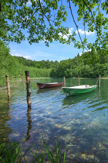 Boote am Salemer See Zwei Boote liegen auf dem Salemer See. Das Wasser unter den Baumkronen ist klar. Das Wetter ist sommerlich mit Sonnenschein.