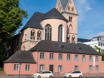 St. Mary in Lyskirchen Die Kirche Sankt Maria in Lyskirchen präsentiert sich mit einem imposanten gotischen Turm. Der rosafarbene Bau mit Schieferdach gliedert sich harmonisch in die historische Umgebung ein.The church of St. Mary in Lyskirchen boasts an imposing Gothic tower. The pink building with its slate roof blends harmoniously into its historical surroundings.