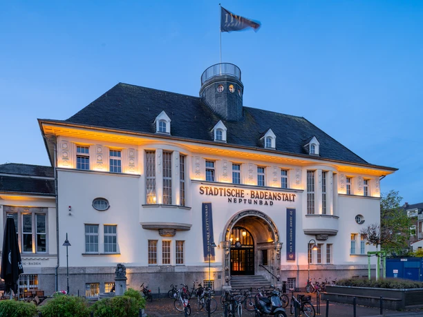 Neptunbad Neptunbad, municipal bathing establishment in an imposing historic building, illuminated at dusk.