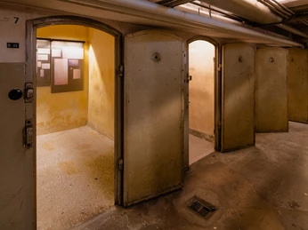 NS Dokumentationszentrum Ein Raum mit mehreren offenen Türen und einigen Tafeln an der Wand.A room with several open doors and a few blackboards on the wall.