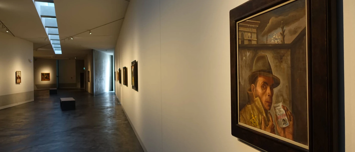 MQ 4 - Selbstbildnis von Felix Nussbaum Ein Selbstbildnis von Felix Nussbaum hängt in einem modernen, hell beleuchteten Ausstellungsraum.