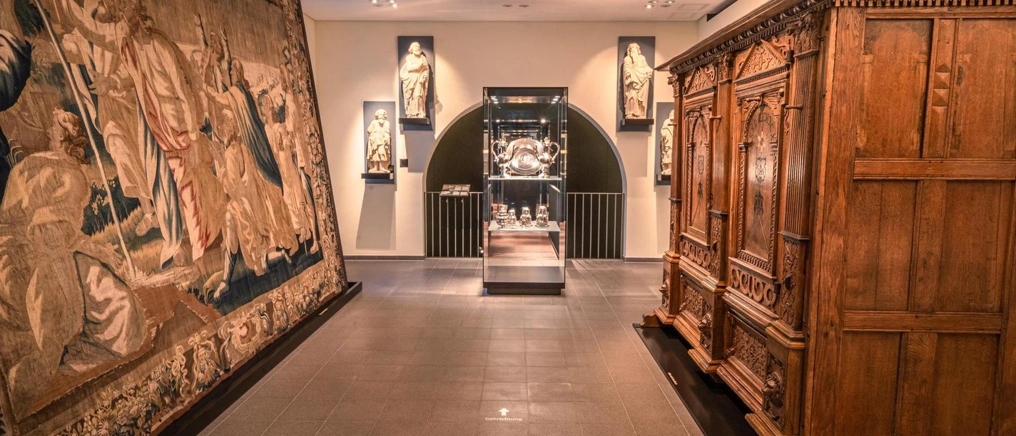 Diözesanmuseum Osnabrück Ausstellungsraum im Diözesanmuseum Osnabrück mit Skulpturen, wertvollem Wandteppich und Holzschrank.