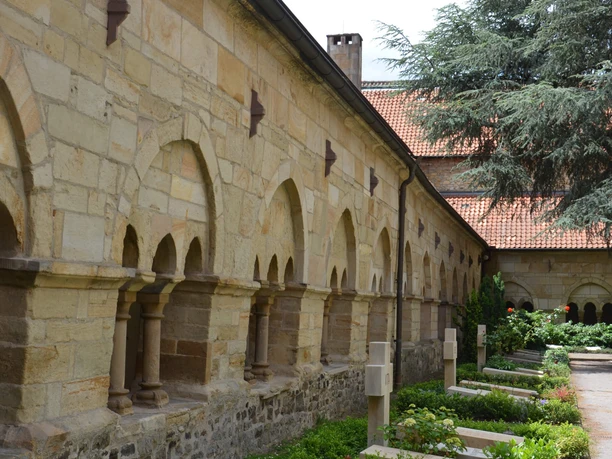 Kreuzgang im Dom St. Petrus Lichtdurchfluteter Kreuzgang im Dom St. Petrus in Osnabrück mit historischen Bögen und gepflegter Gartenanlage.