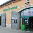 Obstscheune-Krietzschwitz-2.jpg Eingang einer Obstscheune mit grünen Türen und einem grünen Einkaufswagen, daneben ein Schild "Landschlachthof Struppen".