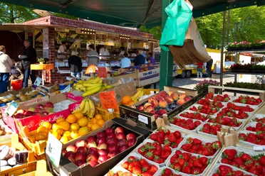 Wochenmarkt vor dem Rathaus.jpg Blick vom Inneren eines Wochenmarktstandes auf frisches Obst.
