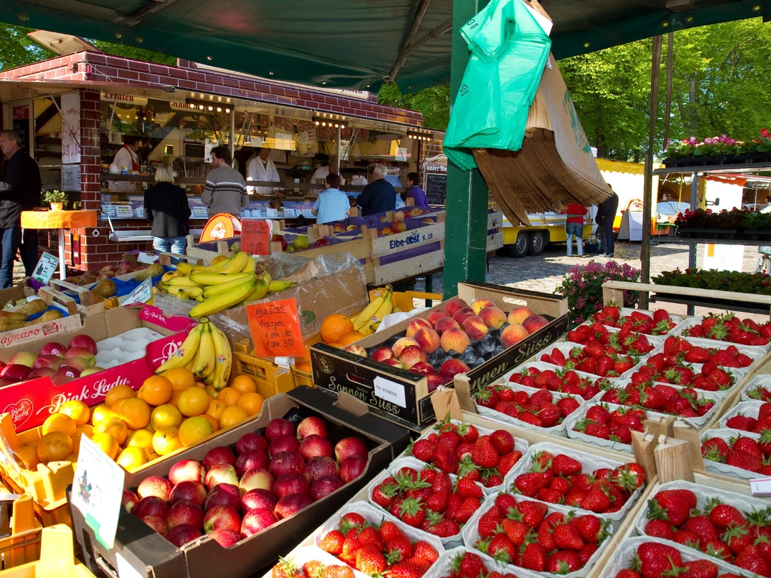Wochenmarkt vor dem Rathaus.jpg Blick vom Inneren eines Wochenmarktstandes auf frisches Obst.