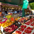 Wochenmarkt vor dem Rathaus.jpg Blick vom Inneren eines Wochenmarktstandes auf frisches Obst.