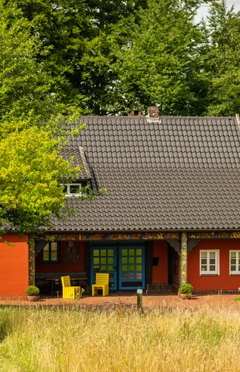Werther-Museum Peter August Böckstiegel-Teutoburger-Wald-Tourismus-D-Ketz-060-CC-BY-SA.jpg Historisches rotes Fachwerkhaus mit ziegelgedecktem Satteldach, umgeben von grünen Bäumen im Sommer.
