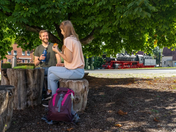 Altenbeken-Lokomotive-044er-Teutoburger-Wald-Tourismus-Patrick-Gawandtka-039.jpg Ein Mann und eine Frau machen Rast am Bahnhof Altenbeken