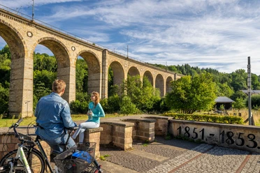 Altenbeken-Viadukt-Teutoburger-Wald-Tourismus-Patrick-Gawandtka-024.jpg Ein Mann und eine Frau machen Pause auf ihrer Fahrradtour vor dem Viadukt Altenbeken
