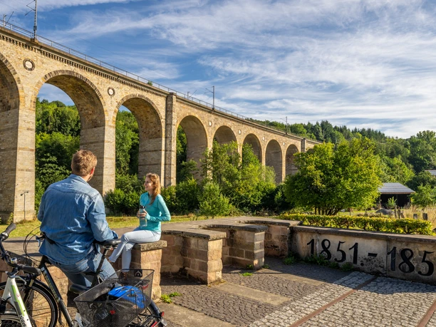 Altenbeken-Viadukt-Teutoburger-Wald-Tourismus-Patrick-Gawandtka-024.jpg Ein Mann und eine Frau machen Pause auf ihrer Fahrradtour vor dem Viadukt Altenbeken