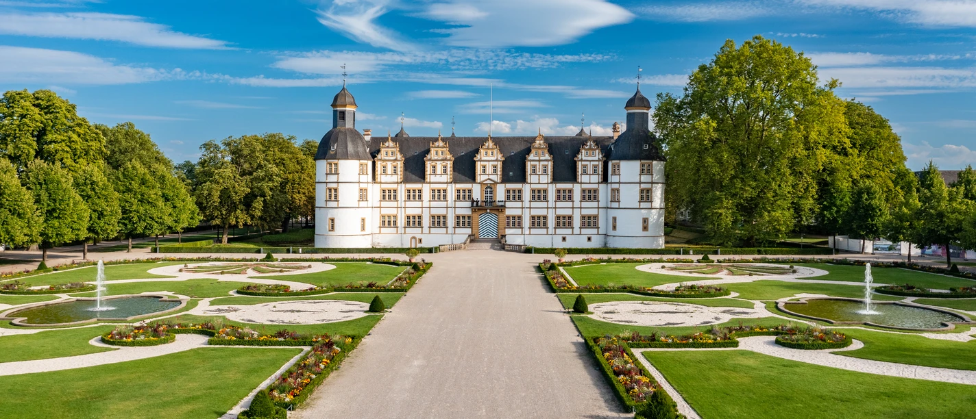 Paderborn-SchlossNeuhaus-Teutoburger-Wald-Tourismus-Patrick-Gawandtka-124.jpg Schloss Neuhaus bei Paderborn mit barockem Garten, symmetrischen Beeten und Springbrunnen im Sommer.