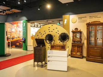 Espelkamp-Schloss Benkhausen-Automatenmuseum-Teutoburger-Wald-Tourismus-D-Ketz-076-CC-BY-SA.jpg Ein Ausstellungsraum mit antiken mechanischen Musikgeräten, darunter Grammophone und Musiktruhen.